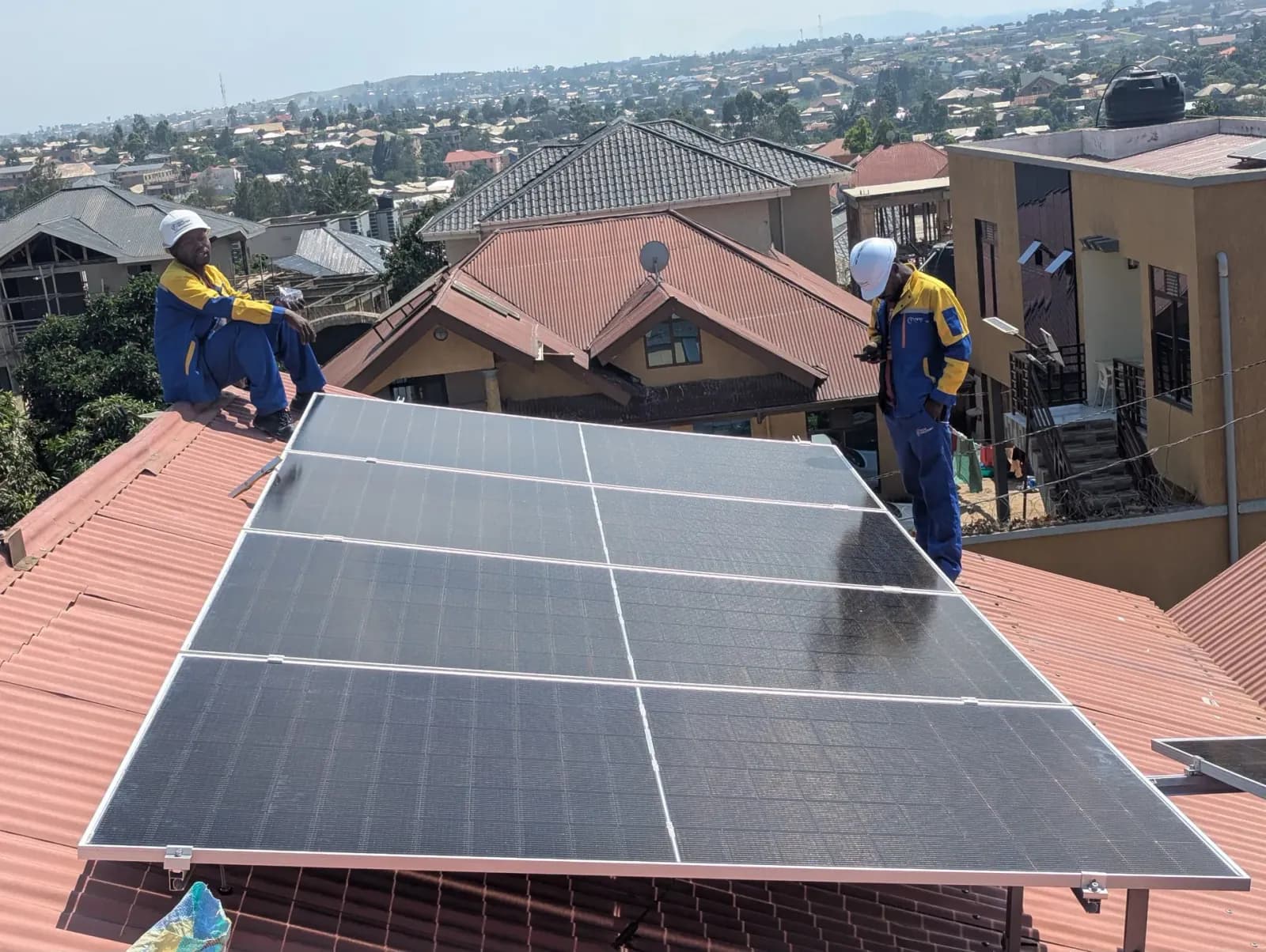 Deux techniciens sur un système solaire en toiture de résidence
